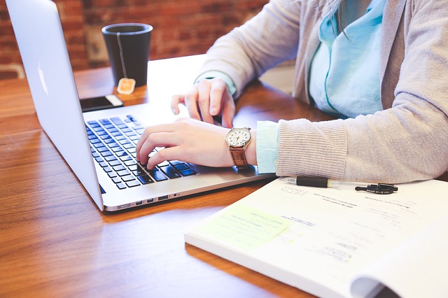 woman typing on computer website bio