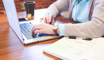 woman typing on computer website bio